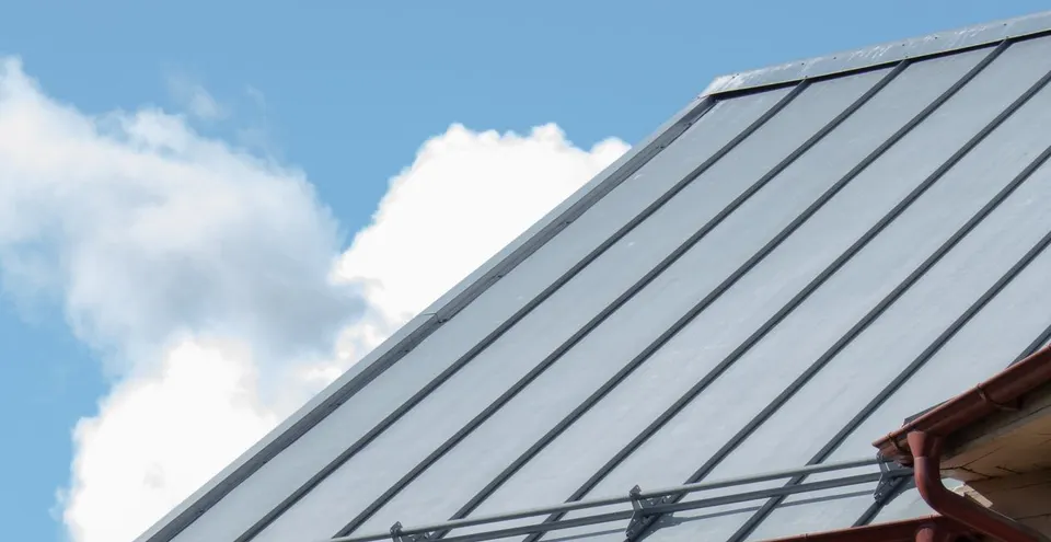 Standing seam metal roof with snow guards above a gutter line
